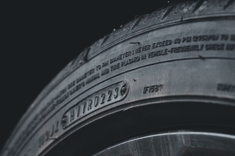 Close-up of a car tire sidewall showing the size and date codes